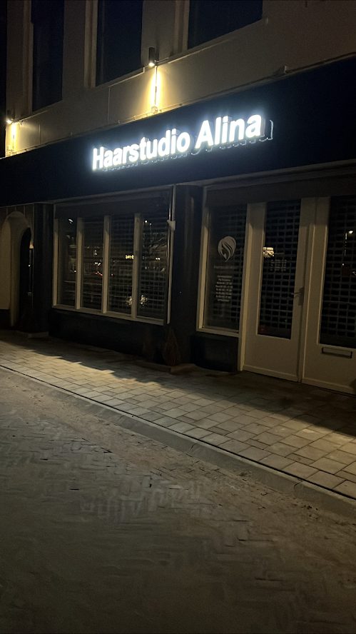 Verlichte gevel van Haarstudio Alina in de avond