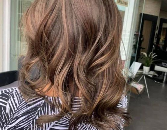Halflang bruin haar met karamel highlights en zachte slagen